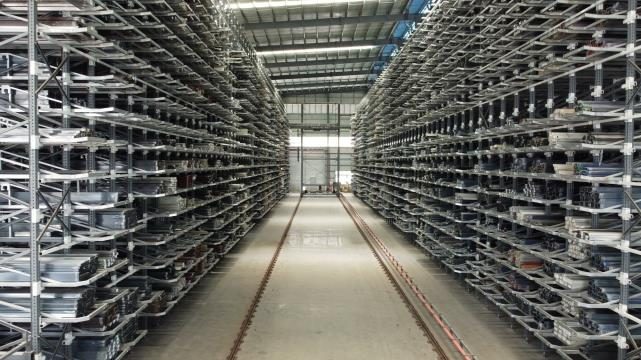 Aisle of a Kinkalteck honeycomb storage system with long steel profiles stored in cassettes on both sides